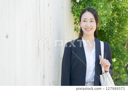 站在新鮮綠樹中的女商人 站在新鮮綠樹中的女商人 127989371