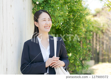 Businesswoman standing among fresh greenery Businesswoman standing among fresh greenery 127989372