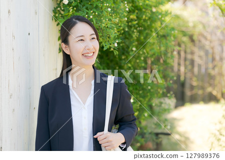 站在新鮮綠樹中的女商人 站在新鮮綠樹中的女商人 127989376