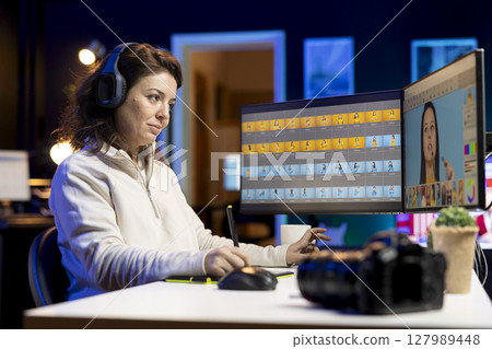 Photo editor editing images in post production company using graphic tablet, enjoying music. Photographer fixing overexposed pictures with touchscreen device, listening songs through headphones 127989448