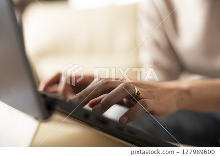 Close up of female hands typing on laptop keyboard, replying to work emails from home. Selective focus showing remote work routine with individual updating business reports and project proposals. Close up of female hands typing on laptop keyboard, replying to work emails from home. Selective focus showing remote work routine with individual updating business reports and project proposals. 127989600