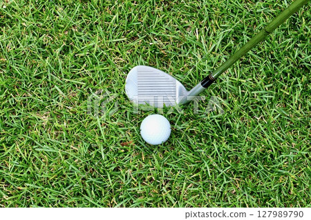 草地上的白色高爾夫球和沙坑挖起桿“粗糙” 草地上的白色高爾夫球和沙坑挖起桿“粗糙” 127989790