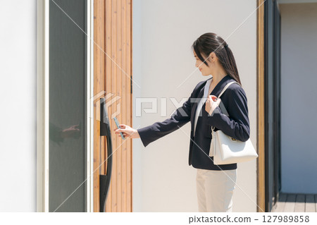 A woman in a suit locking the door 127989858