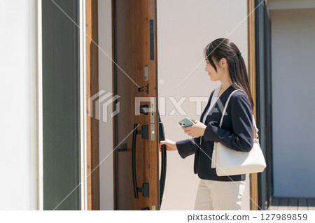 一名穿西裝的女子正在鎖門 127989859
