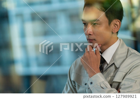 一個穿著工作服的男人在思考 127989921