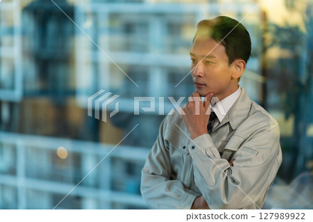A man in work clothes thinking 127989922