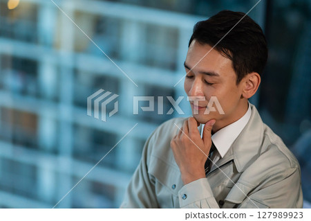 A man in work clothes thinking 127989923