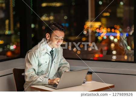 一名工作人員夜間在辦公室操作電腦 127989926