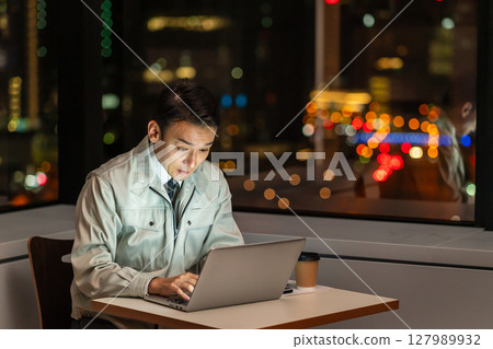 一名工作人員夜間在辦公室操作電腦 一名工作人員夜間在辦公室操作電腦 127989932