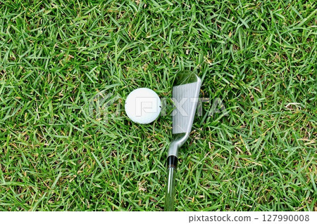 White golf ball and 7 iron on grass "rough" 127990008