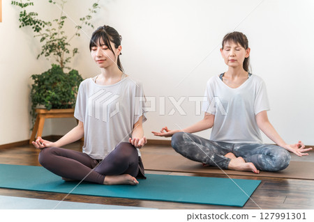 Women learning yoga in a yoga class/pilates (meditation) 127991301