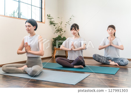 Women doing yoga and pilates in a yoga studio/yoga class (meditation) Women doing yoga and pilates in a yoga studio/yoga class (meditation) 127991303