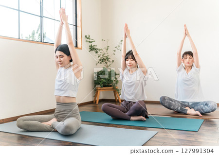 Women who do yoga and pilates in yoga studios and yoga classes (sports gym) 127991304