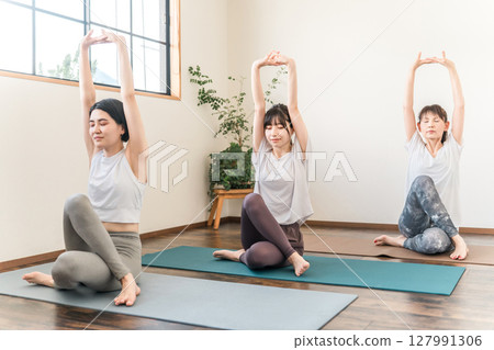Women who do yoga and pilates in yoga studios and yoga classes (sports gym) 127991306