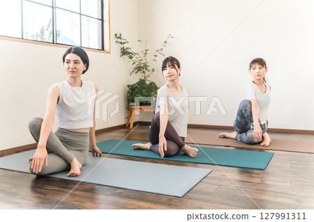 在瑜伽館和瑜伽課（體育館）中練習瑜伽和普拉提的女性 127991311