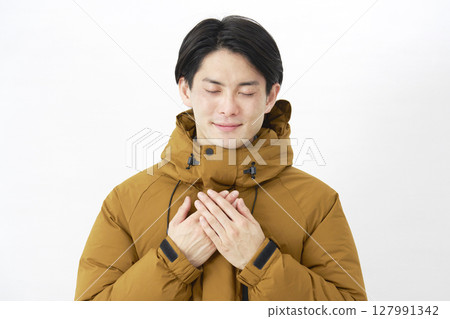 一位穿著羽絨外套的男士在白色背景上感到輕鬆 127991342