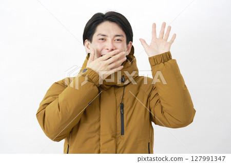 一位穿著羽絨外套的男子在白色背景上驚訝地微笑著 127991347