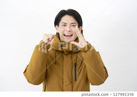 A man wearing a down jacket cheering on a white background 127991356
