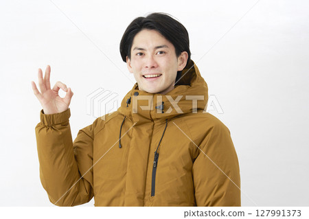 穿著羽絨外套的男人 OK 手勢白色背景 127991373