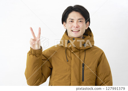 Man wearing down jacket, peace sign, white background Man wearing down jacket, peace sign, white background 127991379