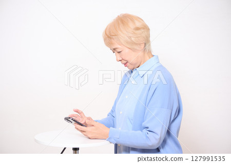 操作智慧型手機的高階女性 127991535