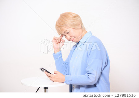 操作智慧型手機的高階女性 操作智慧型手機的高階女性 127991536