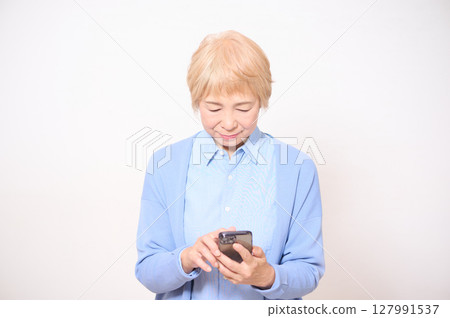 操作智慧型手機的高階女性 操作智慧型手機的高階女性 127991537