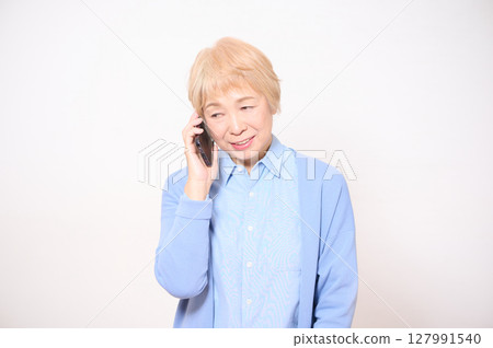 一位資深女性正在用智慧型手機聊天 一位資深女性正在用智慧型手機聊天 127991540