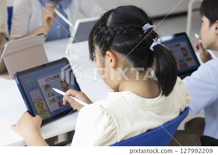 Elementary school students using tablets 127992209