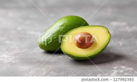 Fresh organic avocado with creamy green flesh and natural pit on textured background for healthy eating 127992393