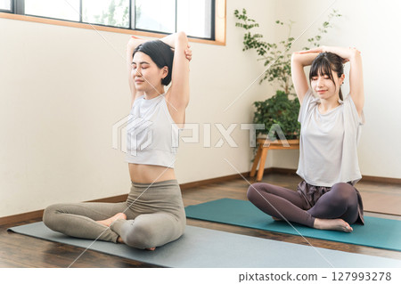 Women who do yoga and pilates in yoga studios and yoga classes (sports gym) 127993278
