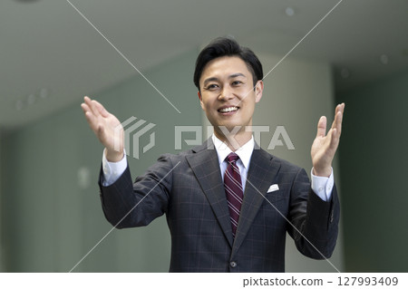 一名 40 多歲、身穿西裝的男子用手勢說話 127993409