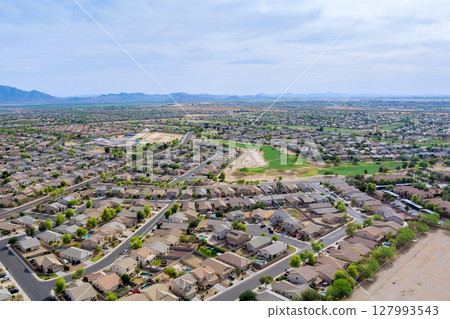 Residential neighborhood with single family homes, organized street grid, southwestern suburban development with geometric street patterns, in Avondale, Maricopa County, Arizona. 127993543
