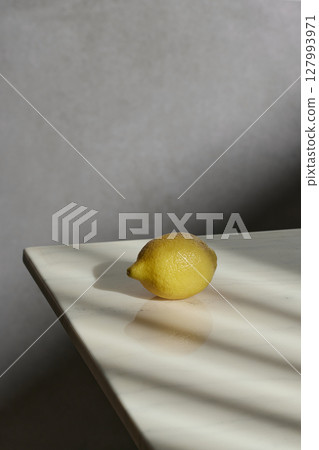 A cozy backdrop with fresh fruits and grass on a table with natural sunlight and shadows. 127993971