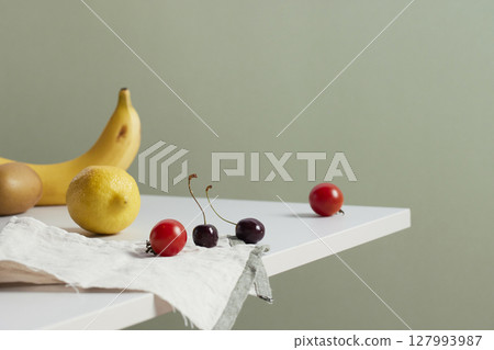 A cozy backdrop with fresh fruits and grass on a table with natural sunlight and shadows. A cozy backdrop with fresh fruits and grass on a table with natural sunlight and shadows. 127993987