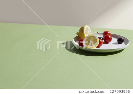 A cozy backdrop with fresh fruits and grass on a table with natural sunlight and shadows. 127993996