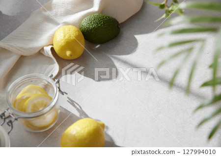 A cozy backdrop with fresh fruits and grass on a table with natural sunlight and shadows. A cozy backdrop with fresh fruits and grass on a table with natural sunlight and shadows. 127994010