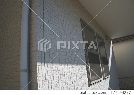 Shadows falling on the exterior wall of a detached house 127994257