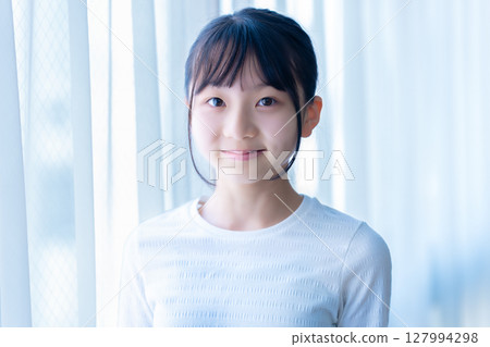 Female junior high school student relaxing by the window Female junior high school student relaxing by the window 127994298
