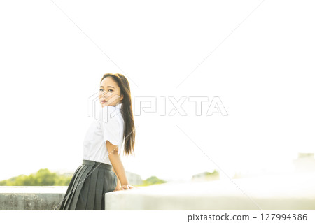 Portrait of a high school girl, looking ennui at the camera Portrait of a high school girl, looking ennui at the camera 127994386