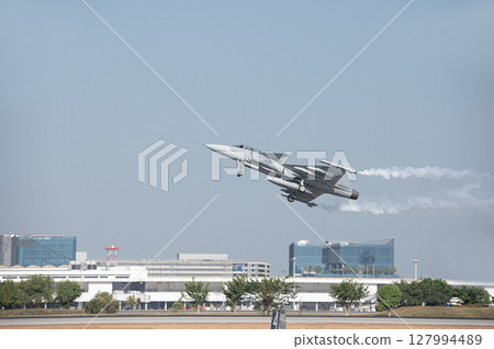 Fighter plane on blue sky background behind technology 127994489