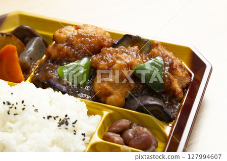 Lunch box with fried chicken on wood background Lunch box with fried chicken on wood background 127994607