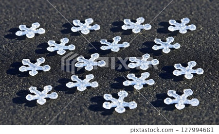 Sparkling Snowflake Confetti on Textured Dark Surface in Bright 127994681