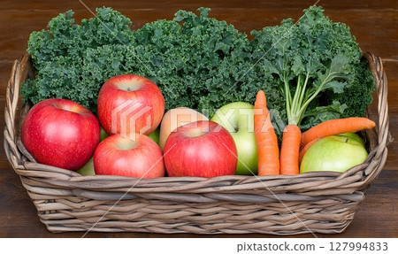Fresh apples carrots and kale in wicker basket healthy food harvest 127994833