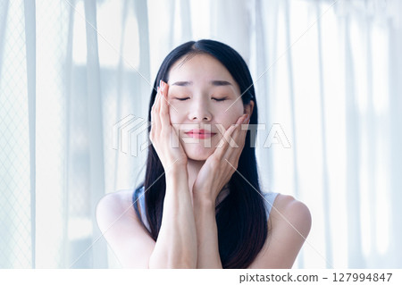 A woman who feels moisturized skin A woman who feels moisturized skin 127994847