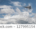 Fighter jet flies through the sky on technology background 127995154