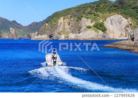 Skin divers and snorkelers depart on the Hirizohama ferry. The blue ocean, the uninhabited Daikon Island, and the reefs are visible. 127995626