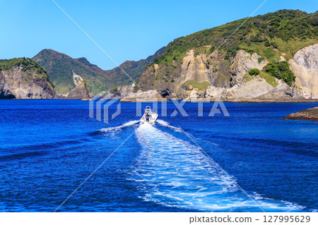 Skin divers and snorkelers depart on the Hirizohama ferry. The blue ocean, the uninhabited Daikon Island, and the reefs are visible. 127995629