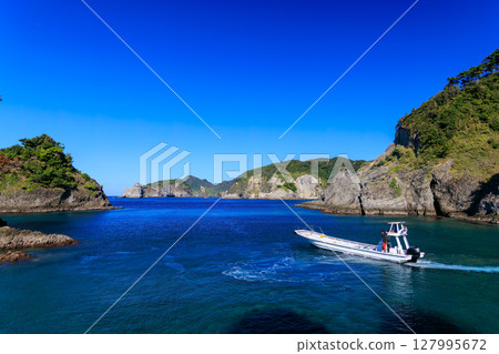 Skin divers and snorkelers depart on the Hirizohama ferry. The blue ocean, the uninhabited Daikon Island, and the reefs are visible. 127995672