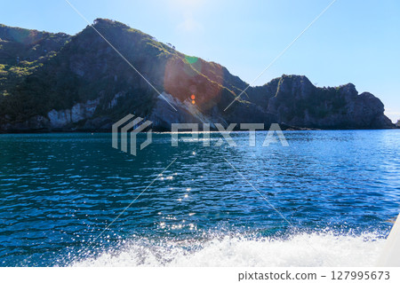 Skin divers and snorkelers depart on the Hirizohama ferry. The blue ocean, the uninhabited Daikon Island, and the reefs are visible. Skin divers and snorkelers depart on the Hirizohama ferry. The blue ocean, the uninhabited Daikon Island, and the reefs are visible. 127995673